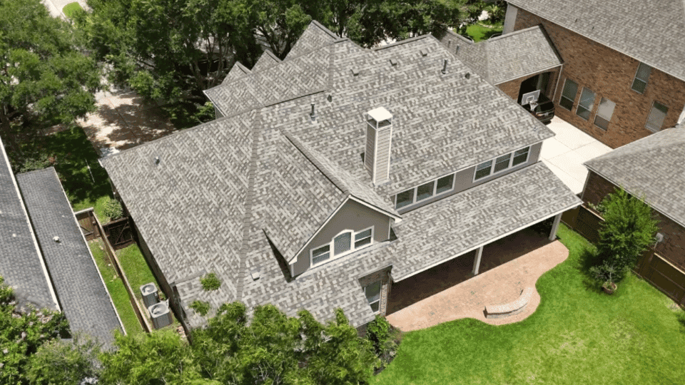 Overhead aerial of a home with a new weathered-gray architectural shingle roof by Rlynt Roofing