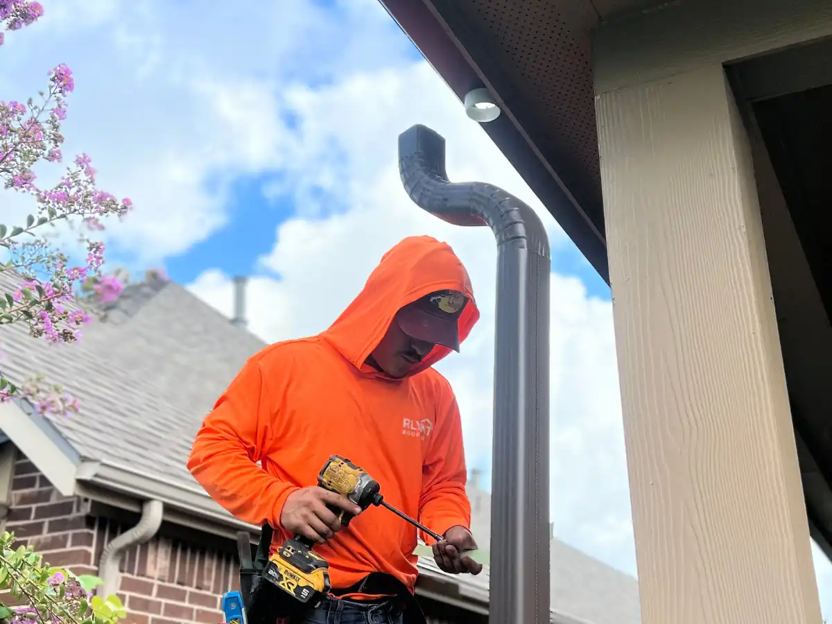 Rlynt Roofing technician installing seamless gutters