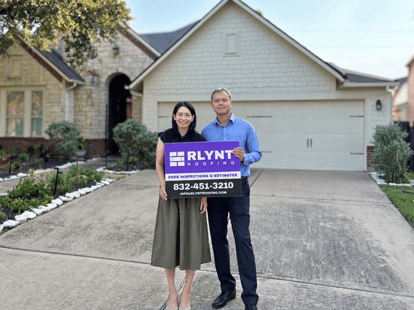 Rlynt Roofing customer holding a yard sign in front of their Cinco Ranch home in Katy, TX