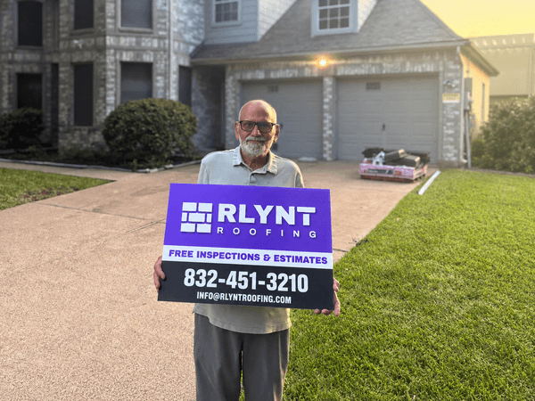 Rlynt Roofing customer holding a yard sign in front of their Clayton Woods home in Houston, TX