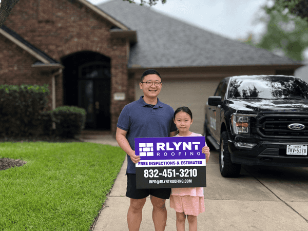 Rlynt Roofing customer holding a yard sign in front of their Falcon Point home in Katy, TX