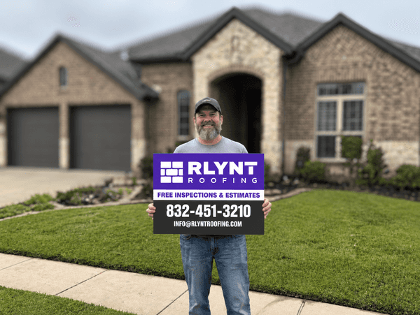 Rlynt Roofing customer holding a yard sign in front of their Weston Lakes home in Fulshear, TX